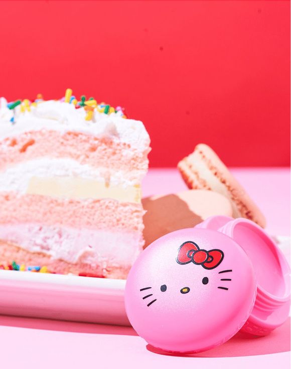 The Creme Shop x Hello Kitty pink macaron lip balm open compact on white background