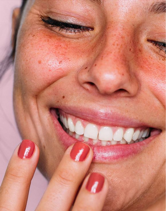 Model smiling with glossy moisturized lips after using Hello Kitty lip balm