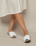 Island Sandal – model wearing white sandals with floral top and green trousers
