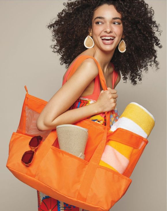 Beach Tote - model carrying orange beach tote loaded with beach essentials