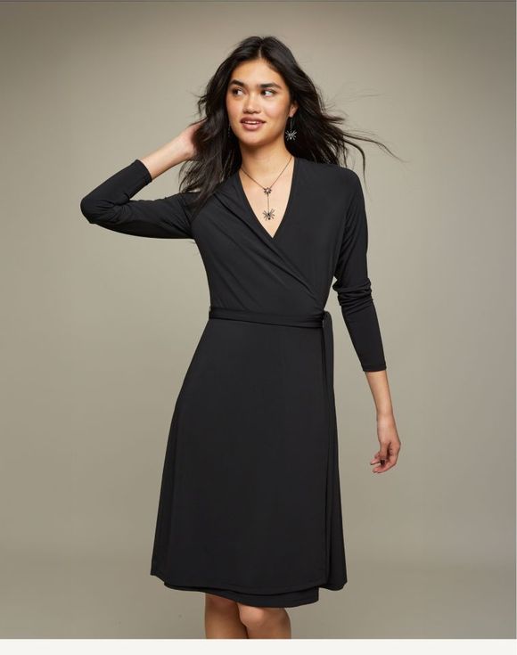 Wrap Dress – model wearing black wrap dress, side-front view showing A-line skirt