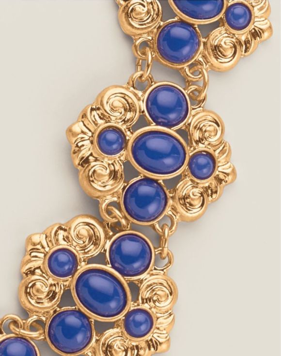 Close-up of Royal Blue Crown Statement Bracelet showing ornate gold-tone scroll panels with royal blue cabochon stones
