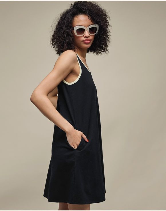 Tank Dress – model wearing black tank dress, side view with hands in pockets