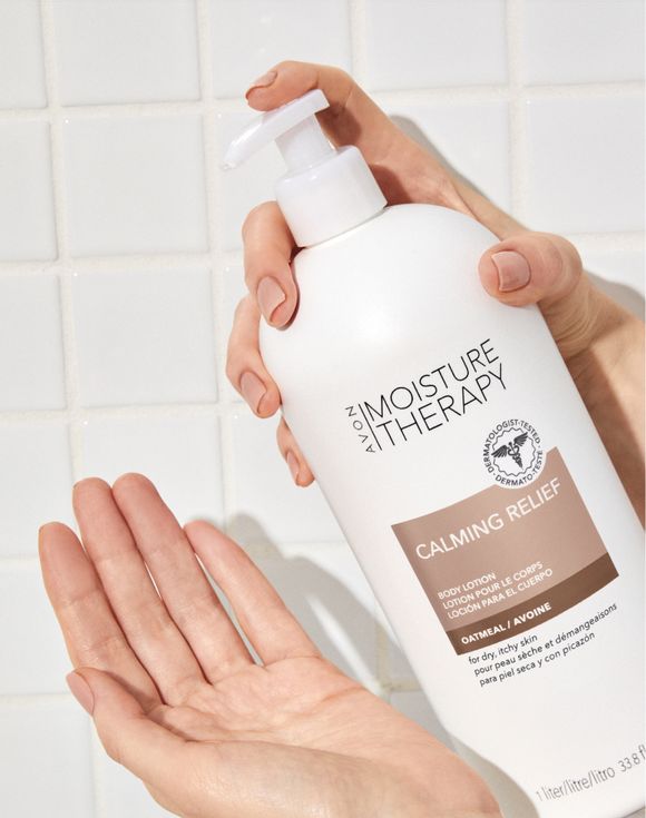 Hands holding Avon Moisture Therapy Calming Relief Body Lotion bottle