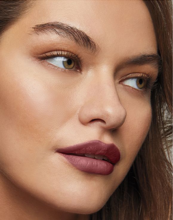 Model wearing fmg Glimmer Lipliner in deep berry shade